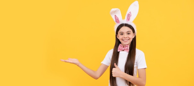 Dziewczynka w uszach królika i muszce prezentująca sprzedaż produktów lub zakupów Wielkanocny plakat poziomy dla dziecka Nagłówek banera internetowego miejsca na kopię króliczka