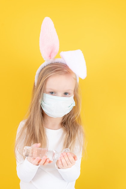 Dziewczynka z uszami królika i maski medyczne za pomocą dezynfekcji rąk