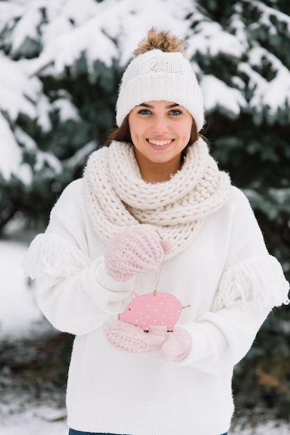 Dziewczyny mienia zabawki świniowaty outside przy zima śnieżnym zimnym dniem