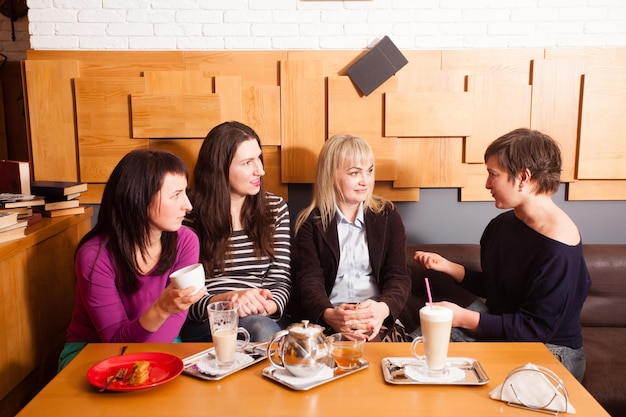 Dziewczyny omawiają najnowsze wiadomości podczas nieformalnego spotkania w kawiarni