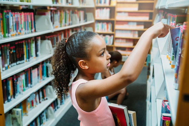 Dziewczyny przeglądające książki w bibliotece publicznej