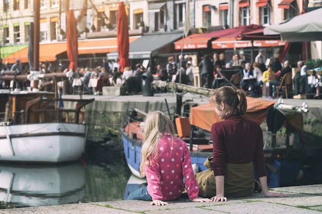 Dziewczyny siedzą na tle słynnego francuskiego miasta Honfleur