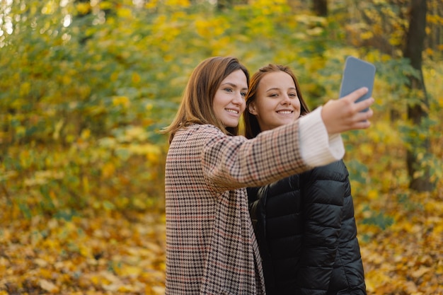 Dziewczyny śmieją się i odbierają selfie przez telefon koncepcja mobilności w stylu życia