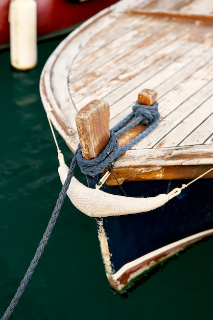 Dziób drewnianej łodzi z liną kotwiczącą w zbliżeniu