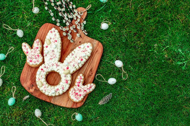 Easter bunny cookies na desce na zielonej trawie