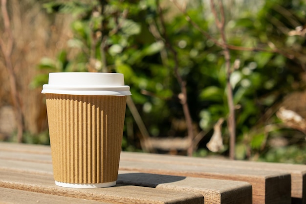 Eco recykling papierowy kubek z kawą lub herbatą na papierze kraft na drewnianym stole śniadanie na ulicy