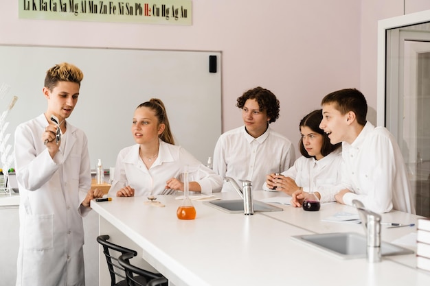 Edukacja Eksperymenty chemiczne na lekcji chemii w szkole Dzieci z klasy trzymają probówki i przeprowadzają eksperymenty w laboratorium
