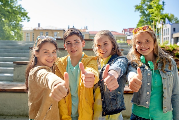edukacja, liceum, przyjaźń, gest i koncepcja ludzi - grupa szczęśliwych nastoletnich uczniów lub przyjaciół pokazujących kciuki na zewnątrz