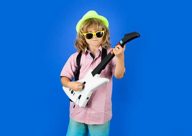 Edukacja muzyczna Portret zabawnego dziecka w okularach przeciwsłonecznych ćwiczącego piosenkę podczas lekcji gry na gitarze