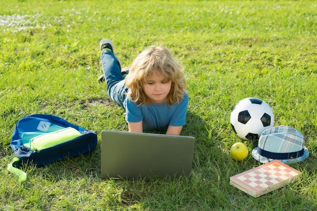 Edukacja na świeżym powietrzu z laptopem leżącym na trawie przy użyciu koncepcji notebooka laptopa edukacji na świeżym powietrzu