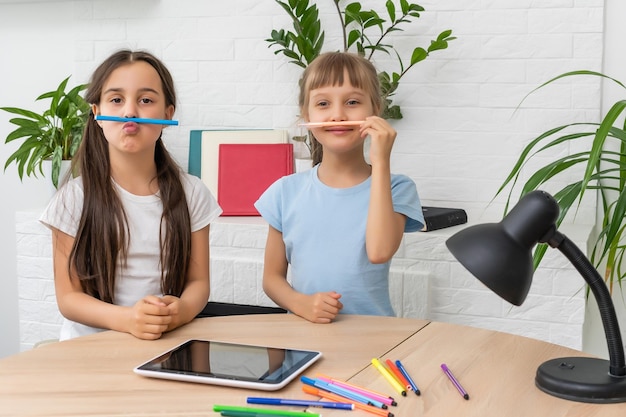 Edukacja online na odległość. Uczennice uczą się w domu i odrabiają lekcje w szkole. Nauka na odległość w domu.