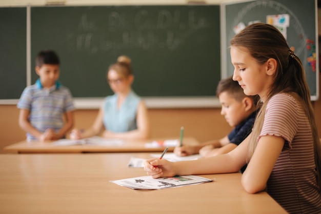 Edukacja w szkole podstawowej i koncepcja osób w grupie szkolnej dzieci z długopisami i zeszytami