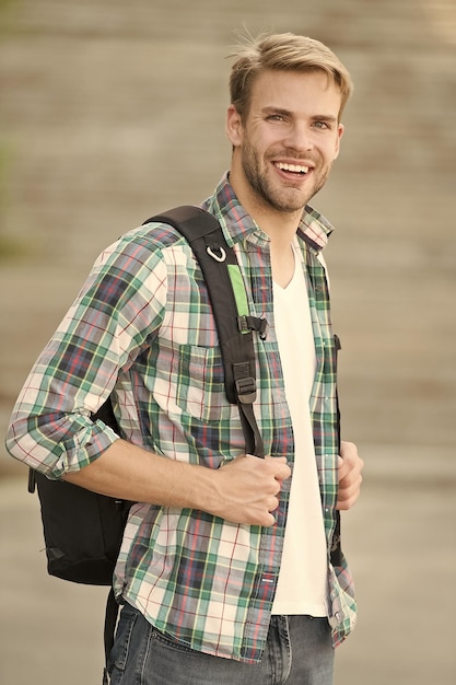 Edukacja zwiększa pomyślną przyszłość Mężczyzna regularny wygląd studenta Edukacja w college'u Życie w college'u Nowoczesny student Student z plecakiem w miejskim pochodzeniu Przystojny facet studiuje na uniwersytecie