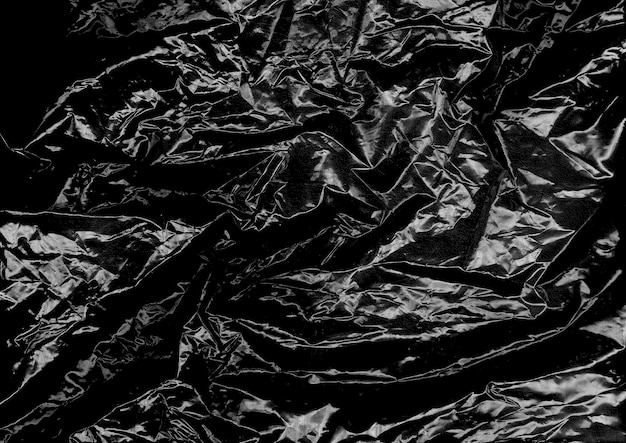 Zdjęcie efekt tekstury zmarszczonej folii plastikowej na czarnym tle