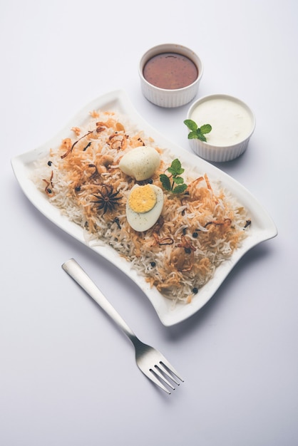 Egg Biryani - ryż basmati gotowany z pieczonymi jajkami masala i przyprawami, podawany z jogurtem, selektywne skupienie