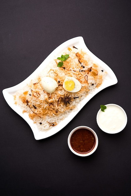 Egg Biryani - ryż basmati gotowany z pieczonymi jajkami masala i przyprawami, podawany z jogurtem, selektywne skupienie