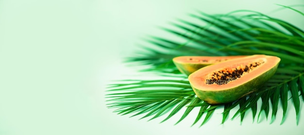 Egzotyczne owoce papai nad tropikalnymi zielonymi liśćmi palmowymi na turkusowym tle Kopiuj przestrzeń Pop-art projekt koncepcja kreatywnego lata Surowe wegańskie jedzenie Baner