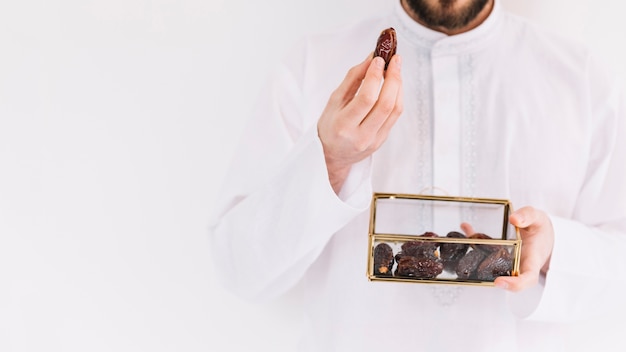 Zdjęcie eid al-fitr pojęcie z mężczyzna mienia pudełkiem daty