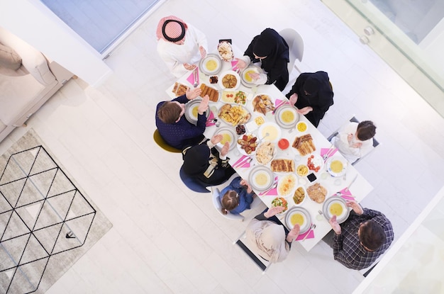 Eid Mubarak Muzułmanie modlą się przed kolacją iftar. Jedzenie tradycyjnych potraw podczas miesiąca biesiadowania Ramadanu w domu. Islamskie halal jedzenie i picie w nowoczesnym zachodnim islamskim widoku z góry