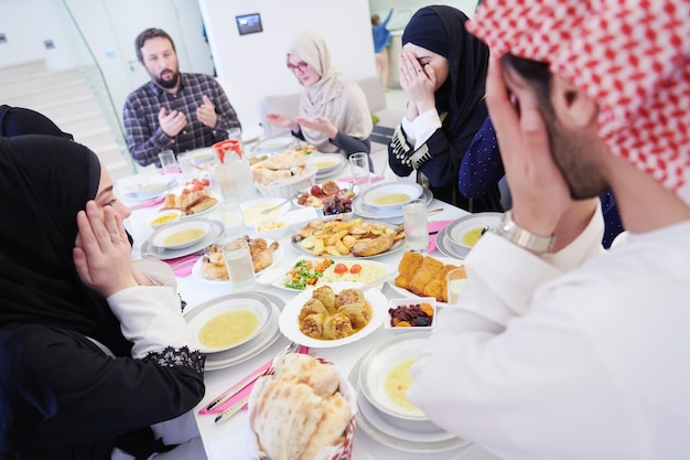 Eid Mubarak Muzułmanie modlą się przed kolacją iftar. Jedzenie tradycyjnych potraw podczas miesiąca biesiadowania Ramadanu w domu. Islamskie jedzenie i picie halal we współczesnej zachodniej rodzinie islamskiej