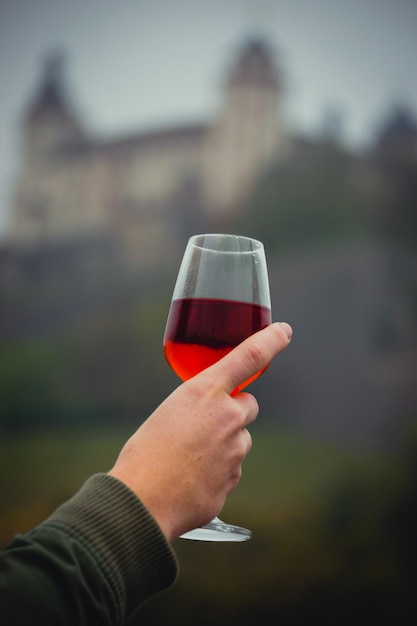 Eine frauenhand halt ein weiglas mit wein in der hand