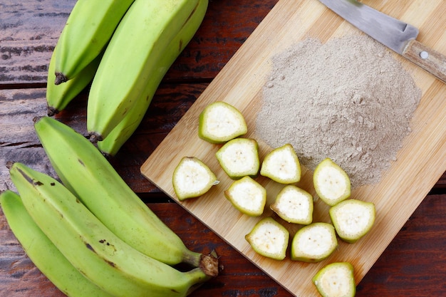 Ekologiczna mąka z zielonego banana zmiażdżona na surowo i sucha w drewnianej misce bezglutenowa mąka widok z góry