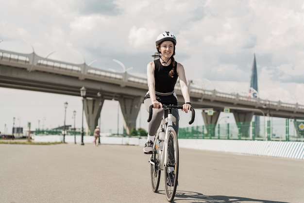 Ekotransport sportowiec jadący rowerem po mieście kobieta w kasku z piegami na twarzy szczęśliwa