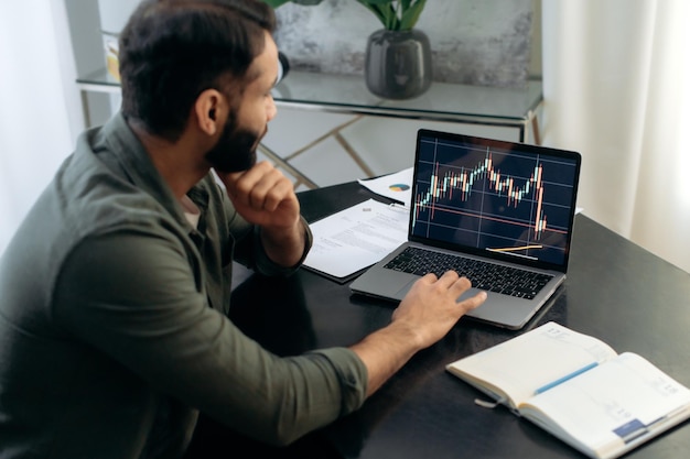 Ekran laptopa z wykresami giełdowymi Inwestor brokerski kryptowaluty korzystający z laptopa do analizy rynku finansowego kryptowaluty kupna lub sprzedaży strategii planowania kryptowaluty