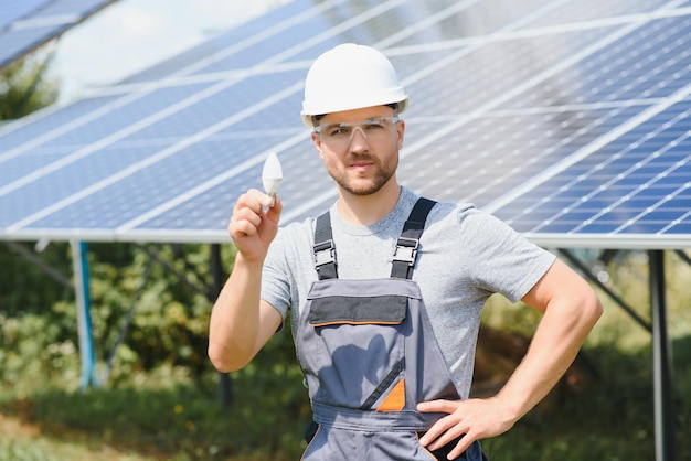 Ekspert techniczny w zakresie paneli fotowoltaicznych fotowoltaicznych pilot wykonuje rutynowe czynności w celu monitorowania systemu przy użyciu czystej energii odnawialnej w dłoni żarówka