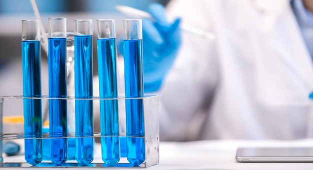 Eksperyment z niebieską cieczą chemiczną w naukowym sprzęcie szklanym w medycynie naukowej odkrycie chemii laboratoryjnej lub biologii za pomocą szklanki probówki lub zlewki i kolby
