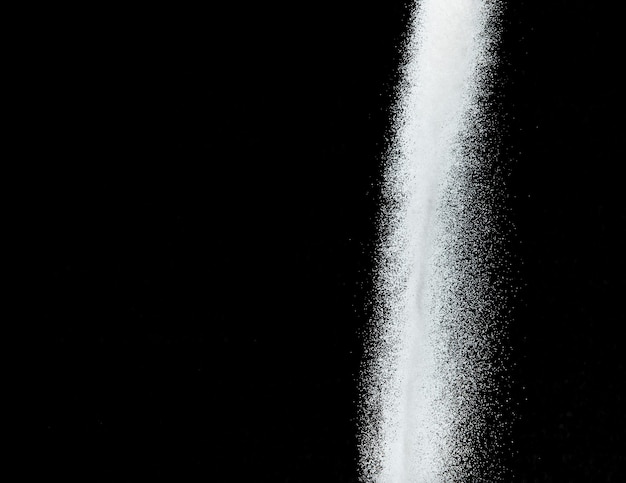 Eksplozja miliona białego piasku Zdjęcie przedstawiające spadający deszcz, śnieg, obfite opady śniegu, latająca burza, Zamrożone zdjęcie na czarnym tle, izolowana nakładka. Malutkie drobne piaski solne jako nauka o cząstkach.