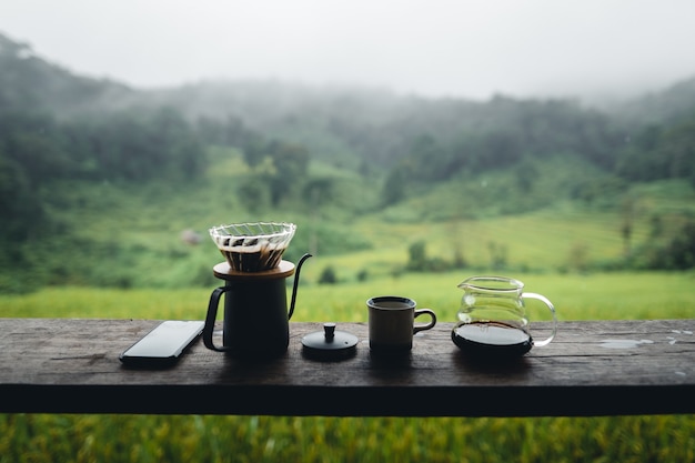 Ekspres do kawy na zewnątrz na drewnianym stole w tle pola ryżowego