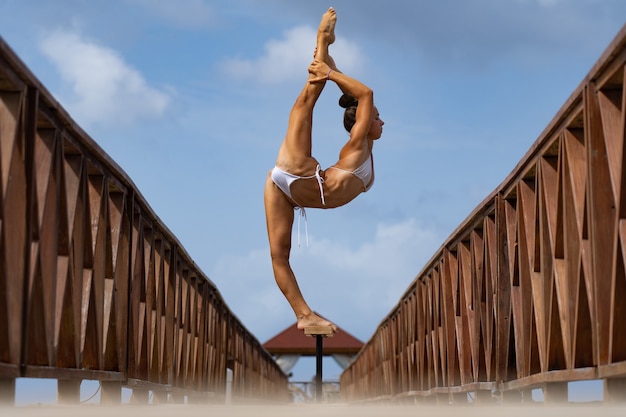 elastyczna artystka cyrkowa utrzymuje równowagę w podziale na moście joga zdrowego stylu życia