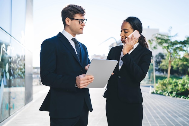 Elegancka bizneswoman z kolegą rozmawiającym przez telefon