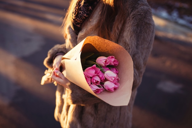 Elegancka dama w futrze z bukietem różowych tulipanów w rzemiośle