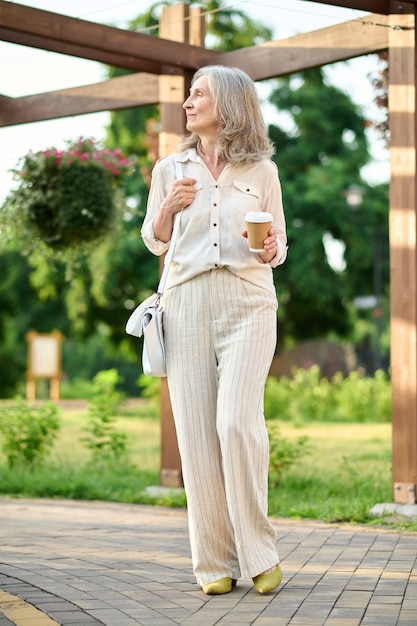 Elegancka dorosła kobieta patrząca w zamyśleniu na bok