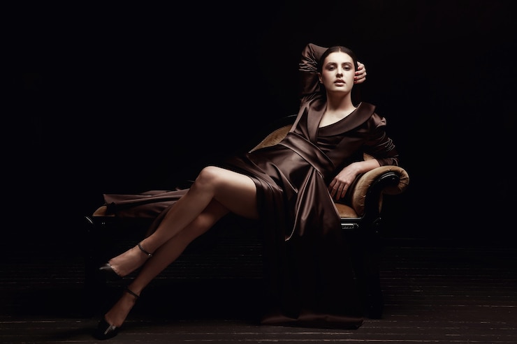 Zdjęcie elegancka kobieta w brązowej sukience na fotelu