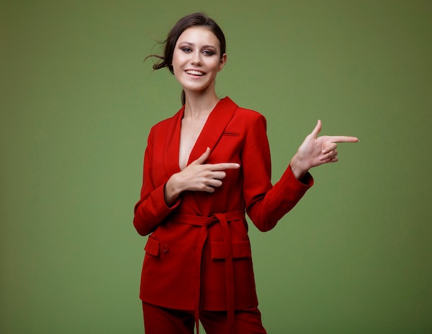 Elegancka kobieta w czerwonych spodniach marynarki na zielonym tle Studio Shot Businesswoman