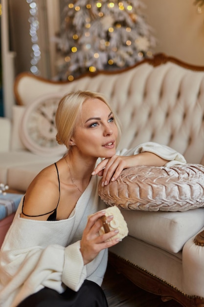 Elegancka kobieta w domu na kanapie z filiżanką herbaty