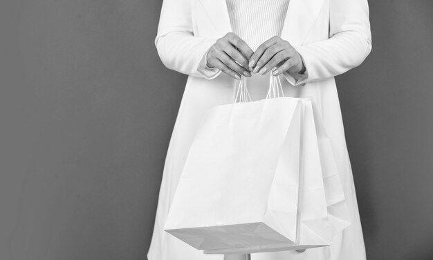 Zdjęcie elegancka kobieta zakupoholiczka dziewczyna shopper trzymaj papierową torebkę kup prezenty online sklep z upominkami na każde wakacje wyprzedaż w czarny piątek miły zakup nosić torby na zakupy miejsce na zakupy