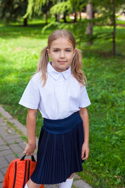 Elegancka uczennica spaceru w parku, koncepcja uczenia się. Mundurek szkolny. 1 września