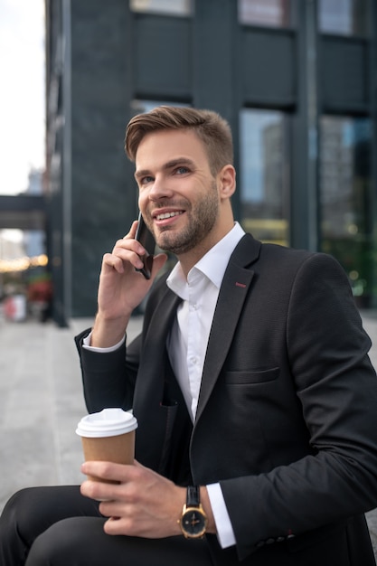 Elegancki biznesmen mężczyzna kawę i rozmawia przez telefon