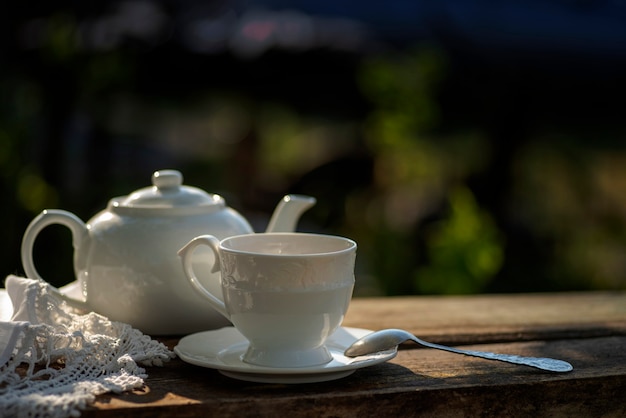 Elegancki kubek koronkowy obrus czajniczek drewniany stół Śniadanie na świeżym powietrzu piknik brunch wiosenny nastrój