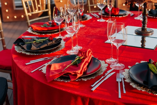 Elegancki wystrój aranżacji obiadowej obrus talerze z serwetkami i kieliszki ze świeżych róż sztućce