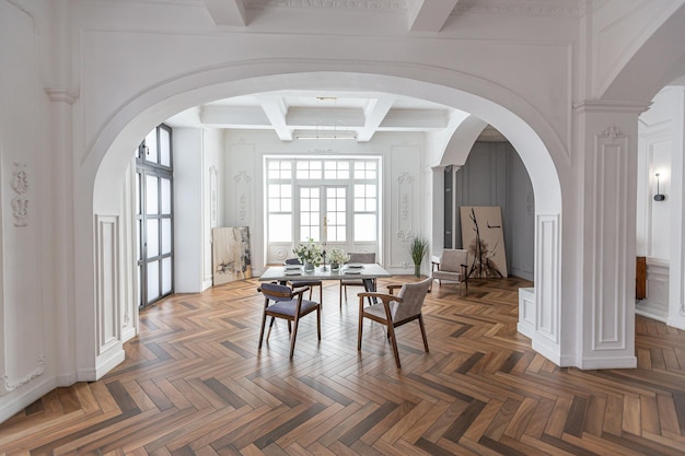 eleganckie, drogie, jasne wnętrze ogromnego salonu w historycznym rezydencji z łukowymi kolumnami i białymi ścianami ozdobionymi ozdobami i sztuką