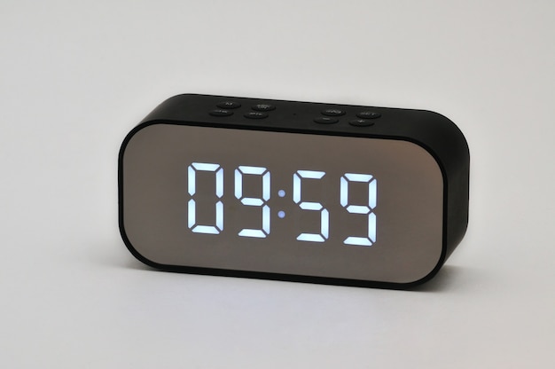 Zdjęcie elektroniczny zegar ciekłokrystaliczny z cyfrowym wskazaniem czasu i daty na białym tle