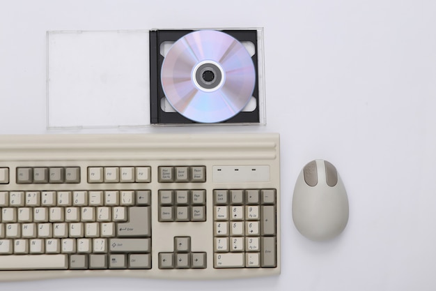 Zdjęcie elektronika retro, technologia pc lata 90-te. klawiatura pc, mysz, cd na białym tle. widok z góry