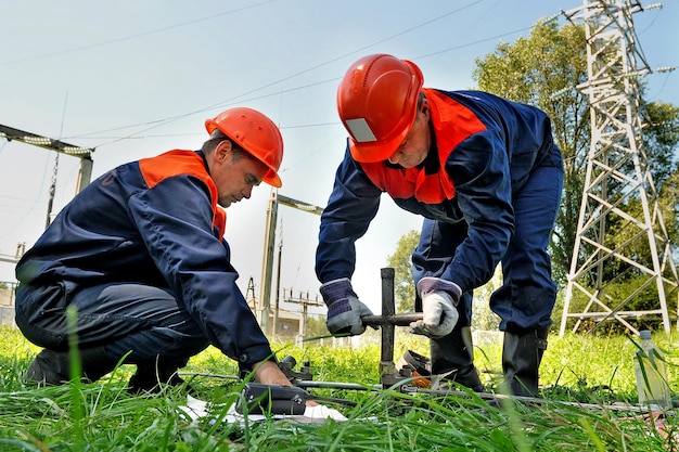 Elektrycy skręcają przewody elektryczne za pomocą specjalnego sprzętu