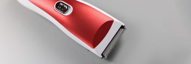 Elektryczna maszyna do przycinania włosów w kolorze czerwonym na szarej powierzchni