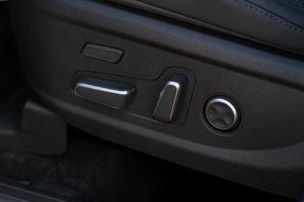 Elektryczny panel sterowania regulacją fotela samochodowego z bliska. Regulowana pozycja fotelika samochodowego. Wnętrze samochodu.
